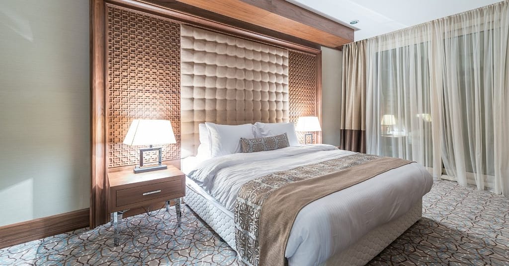 Bold, Artistic, and Eclectic Bedroom Styles
Eclectic primary bedroom with vibrant blue walls, floral wall art, white bedding, and patterned benches at the foot of the bed.Image Source: Home StratosphereBold, Artistic, and Eclectic Bedroom Styles
Bedrooms that make bold statements allow for personal expression through vivid colors, unexpected combinations, and artistic elements. These styles embrace individuality over convention.21. Eclectic Bedroom Design
Eclectic bedrooms blend different design elements, mixing patterns, vintage decor, and vibrant colors. This style celebrates the freedom to combine what you love without rigid rules. The key to successful eclectic design is maintaining a cohesive thread—perhaps through color palette or materials—that connects diverse pieces. Pattern mixing is essential, from subtly patterned wallpaper alongside patterned rugs to oversized floral designs that provide visual interest.22. Industrial Bedroom Design
Industrial bedrooms showcase raw, utilitarian elements inspired by old factories. Essential components include weathered wood, exposed brick, concrete surfaces, and metal accents. This minimal, esthetic style embraces open spaces with clutter-free environments. Industrial bedrooms often feature exposed ducts, unfinished wood, and sleek bedspreads that create simple yet visually pleasing spaces.23. Neo-Industrial Bedroom
Neo-Industrial bedrooms refresh factory-inspired interiors with luxury elements. This contemporary style draws from industrial revolution esthetics while incorporating modern functionality. A concrete accent wall paired with exposed ductwork and warm wood floors creates a high-end look without sacrificing character. Neo-Industrial design celebrates the marriage of form and function, highlighting natural textures of industrial materials like concrete, steel, and wood.24. Art Deco Bedroom
Art Deco bedrooms channel 1920s glamor through geometric patterns, bold colors, and luxurious materials. Signature elements include curved headboards, brass accents, and symmetrical arrangements. The style employs rich jewel tones like emerald green and deep blue alongside metallics such as chrome and brass. Mirrors, marble, velvet upholstery, and globe lighting fixtures enhance the sophisticated atmosphere.25. Maximalist Bedroom Style
Maximalist bedrooms embrace a "more is more" philosophy through bold colors, mixed patterns, and layered textures. Unlike minimalism, this approach celebrates personality through carefully curated displays that might appear chaotic but remain intentional. Creating a maximalist bedroom involves gallery walls, statement lighting, ornate headboards, and varied textiles that pack style and attitude into your space.26. Mid-Century Modern Bedroom
Mid-Century Modern bedrooms feature clean lines, minimal ornamentation, and natural materials. This style emerged between 1940-1970, defined by vibrant colors in wall art and textiles. Furniture often displays low profiles, tapered legs, and sleek silhouettes. Solid wood—especially walnut, teak, and rosewood—defines this esthetic alongside geometric shapes and balanced, symmetrical arrangements.27. Zen Bedroom Retreat
Zen bedrooms create peaceful sanctuaries through simplicity, natural elements, and intentional design. These spaces emphasize curved shapes, low-profile furniture, and minimalist esthetics. Essential elements include neutral color palettes, natural light, plush textures, and symmetrical layouts. For truly zen spaces, consider removing electronics, incorporating plants, and ensuring every item serves a purpose or brings joy.Conclusion
Your bedroom serves as more than just a sleeping space—it represents your personal sanctuary where style meets comfort. Throughout this exploration of 27 distinct bedroom design styles, one thing remains clear: possibilities for creating your ideal retreat are virtually endless.Whether you gravitate toward timeless traditional elegance, sleek modern minimalism, nature-inspired rustic charm, or bold artistic expression, each style offers unique elements to transform your bedroom. Additionally, many homeowners find joy in mixing complementary aspects from different styles to create spaces that truly reflect their personalities.Remember that bedroom redesigns typically cost between ₹2-6 lakhs depending on size, materials, and complexity. However, you can certainly incorporate elements of these styles through smaller updates like textiles, paint, or statement pieces if a complete overhaul exceeds your current budget.Above all, your bedroom should feel like a personal haven that welcomes you at day's end and energizes you each morning. The perfect bedroom balances esthetic appeal with practical functionality while honoring your individual preferences. After all, the most successful bedroom designs prioritize not just how spaces look, but how they make you feel.Take inspiration from these diverse styles, then customize your approach to create a bedroom that perfectly aligns with your lifestyle, needs, and dreams. The result will be a deeply personal retreat that supports both restful sleep and waking inspiration.FAQs
Q1. What are some popular bedroom interior design styles for 2025? Popular bedroom styles for 2025 include modern designs with smart storage solutions, biophilic elements that incorporate nature, and spaces with soothing, layered textures. There's also a trend towards warm, cozy spaces with tone-on-tone colors and strategic lighting.Q2. How can I create a traditional bedroom with a modern twist? To create a traditional bedroom with a modern twist, consider a transitional style. This approach combines classic elements like crown molding and upholstered headboards with modern touches such as clean-lined furniture and a monochromatic color scheme. Balance traditional patterns with contemporary textures for a timeless yet fresh look.Q3. What are the key elements of a minimalist bedroom design? Key elements of a minimalist bedroom include essential furniture with clean, straight lines, light colors, and clever integrated storage solutions. The focus is on creating a calm environment through decluttered sightlines and intentional choices, not emptiness. Natural materials and neutral color palettes are often used to enhance the serene atmosphere.Q4. How can I incorporate nature-inspired elements into my bedroom? To incorporate nature-inspired elements, consider a biophilic design approach. Add potted plants, use natural materials like wood and stone, and choose organic cotton or hemp linens. Incorporate nature-inspired colors and ensure ample natural light. You can also add textural elements like jute rugs or woven light fixtures for a coastal or rustic touch.Q5. What's the difference between eclectic and maximalist bedroom styles? While both styles embrace bold choices, eclectic bedrooms focus on blending different design elements with a cohesive thread, such as a color palette or material theme. Maximalist bedrooms, on the other hand, follow a "more is more" philosophy, celebrating personality through carefully curated displays of bold colors, mixed patterns, and layered textures that may appear chaotic but remain intentional.